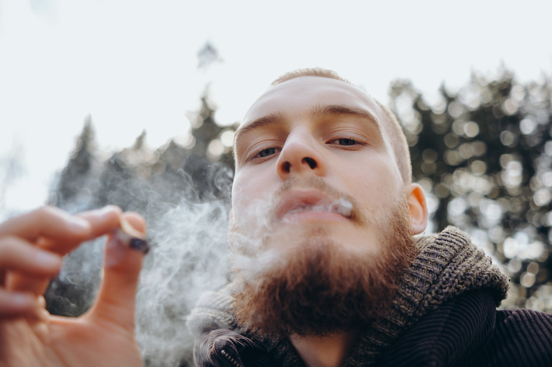 Young guy smoking a cannabis joint