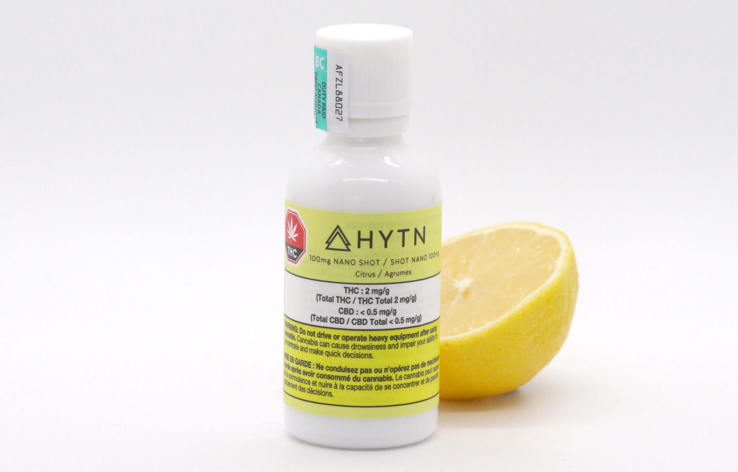 A bottle of 100mg Nano Shot by HYTN with a halved lemon.